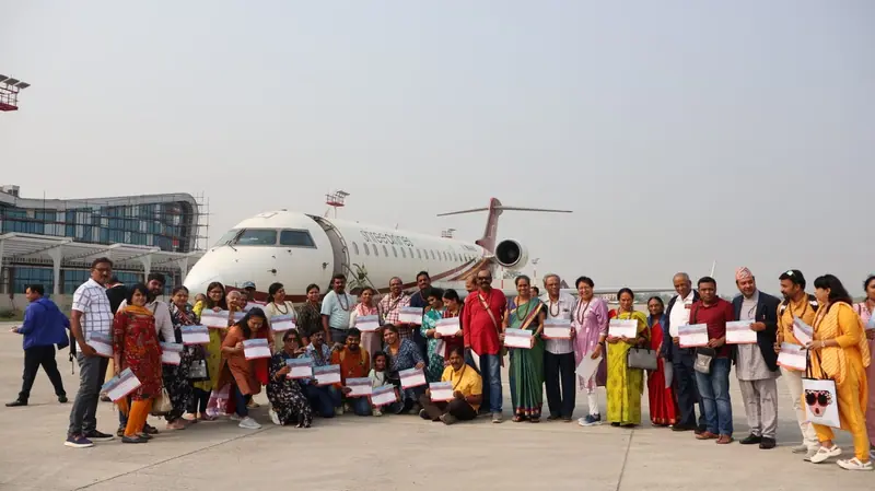 Yatris holding certificates in front of the charter aircraft