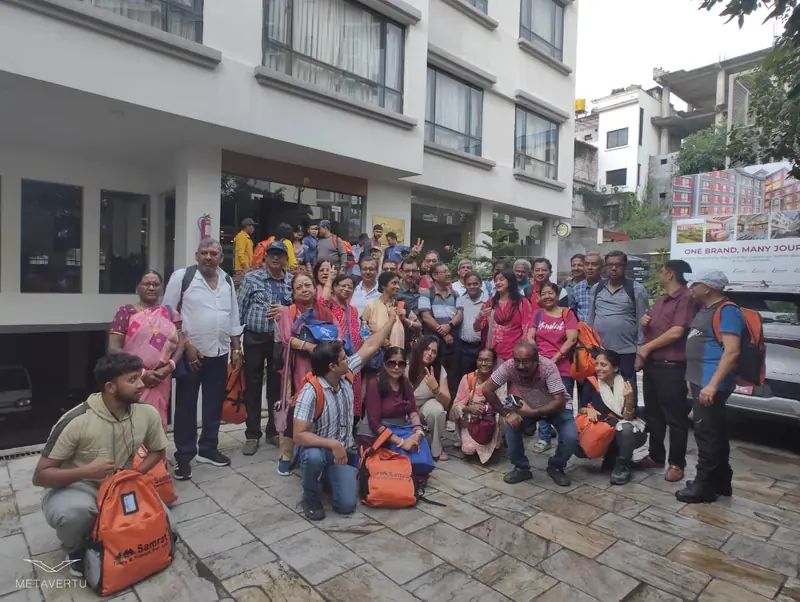 A large group of yatris with backpacks outside their hotel